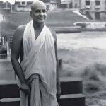 Swami Krishnananda standing peacefully with walking stick