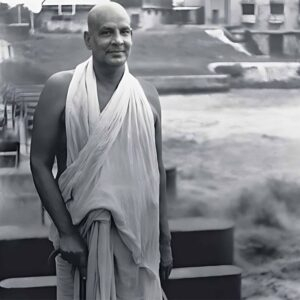 Swami Krishnananda standing peacefully with walking stick
