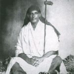Young Swami Sivananda meditating with staff
