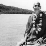 Swami Sivananda beside river sharing timeless spiritual wisdom