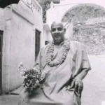 Swami Sivananda holding flowers with peaceful smile