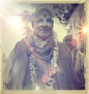 Swami Sivananda wearing flower garland with peaceful smile