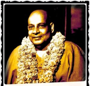 Swami Sivananda wearing sacred flower garland