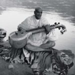 Swami Sivananda playing veena on tiger skin.