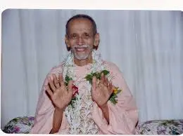 Smiling Swami Chidananda blessing devotees with raised hands and compassion gracefully
