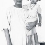 Swami Sivananda holding young child lovingly