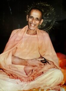 Smiling Hindu monk seated peacefully in saffron robes
