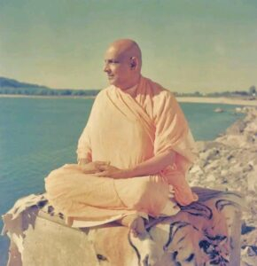 Swami Sivananda meditating peacefully beside sacred river