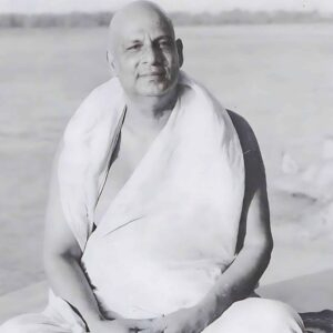 Swami Sivananda sitting peacefully beside sacred river