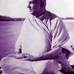 Swami Sivananda meditating peacefully beside sacred river