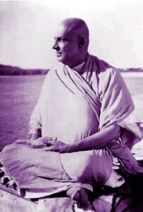 Swami Sivananda meditating peacefully beside sacred river