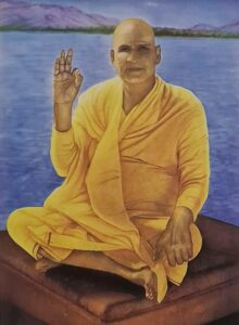 Swami Sivananda blessing devotees beside peaceful river