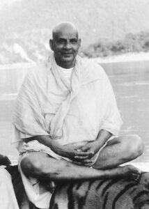 Swami Sivananda meditating beside peaceful riverside landscape
