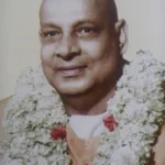 Swami Sivananda smiling with sacred flower garlands