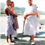 Swami Sivananda walking with disciples beside sacred river