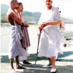 Swami Sivananda walking with disciples beside sacred river