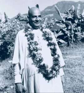 Swami Sivananda wearing flower garland in garden