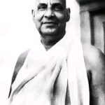 Black and white smiling portrait of Sivananda.
