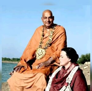 Swami Sivananda sitting outside with a devotee.