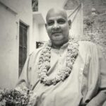 Swami Sivananda wearing flower garland smiling peacefully