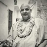 Swami Sivananda wearing flower garland smiling peacefully