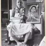 Swami Sivananda holding sacred portrait with reverence