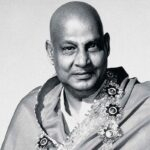 Swami Sivananda smiling with flower garland gracefully