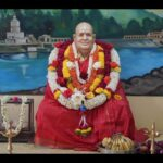 Bhakti guru adorned with flower garlands inspiring devoted seekers peacefully together