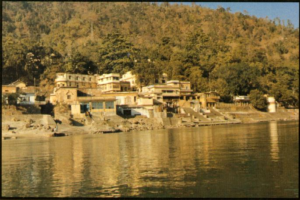 Peaceful riverside spiritual institution surrounded by forested Himalayan landscape