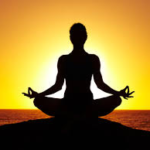 Person meditating peacefully during golden sunrise for mindfulness
