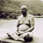 Swami Sivananda meditating beside a peaceful river