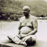 Swami Sivananda meditating beside a peaceful river
