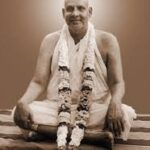 Swami Sivananda seated with sacred flower garland