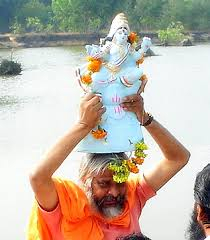 Devotee carrying Lord Ganesha idol with joyful devotion