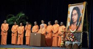 Monks honoring guru portrait during spiritual gathering with devotion and reverence