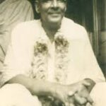 Swami Sivananda smiling with flower garland image