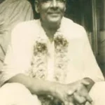 Swami Sivananda smiling with flower garland image