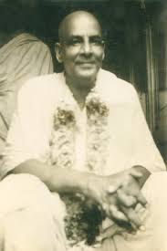Swami Sivananda seated wearing flower garland image