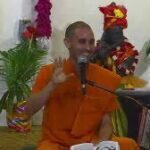 Bhakti Yoga teacher delivering spiritual discourse with devotional enthusiasm indoors