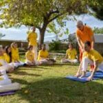 Spiritual aspirants practicing yoga and meditation outdoors under a tree