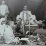 Devotees gathered around Sri Swami Sivananda during a spiritual discourse and devotional gathering