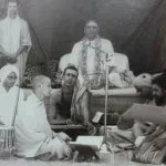 Devotees gathered around Sri Swami Sivananda during a spiritual discourse and devotional gathering