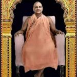 Swami Sivananda sitting in ornate golden frame.