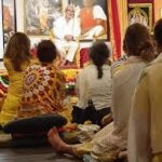 Devotees listening to a spiritual discourse in a meditation hall