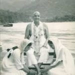 Swami Sivananda with disciples beside peaceful river