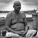 Swami Sivananda practicing meditation beside sacred river peacefully