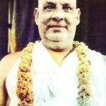 Swami Sivananda wearing flower garland smiling peacefully