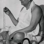 Swami Sivananda chanting mantra with sacred prayer beads