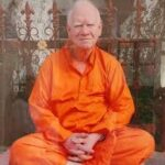 Elder monk seated peacefully in meditation pose