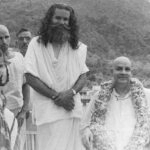 Swami Sivananda with devotees by riverside image